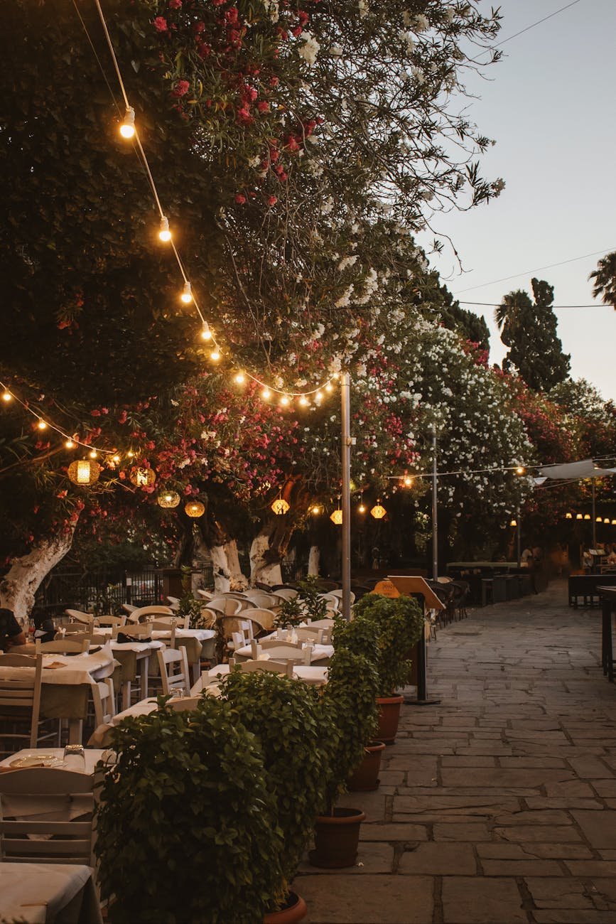 lights over the tables and chairs on a restaurant patio