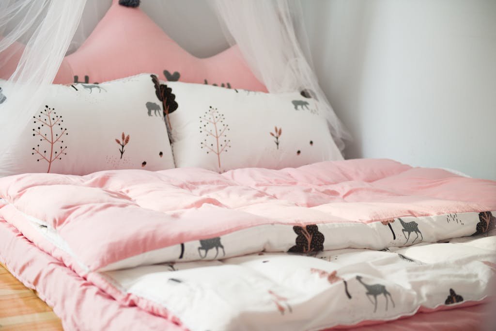 A cozy bedroom with pink bedding and animal patterns, perfect for relaxation.