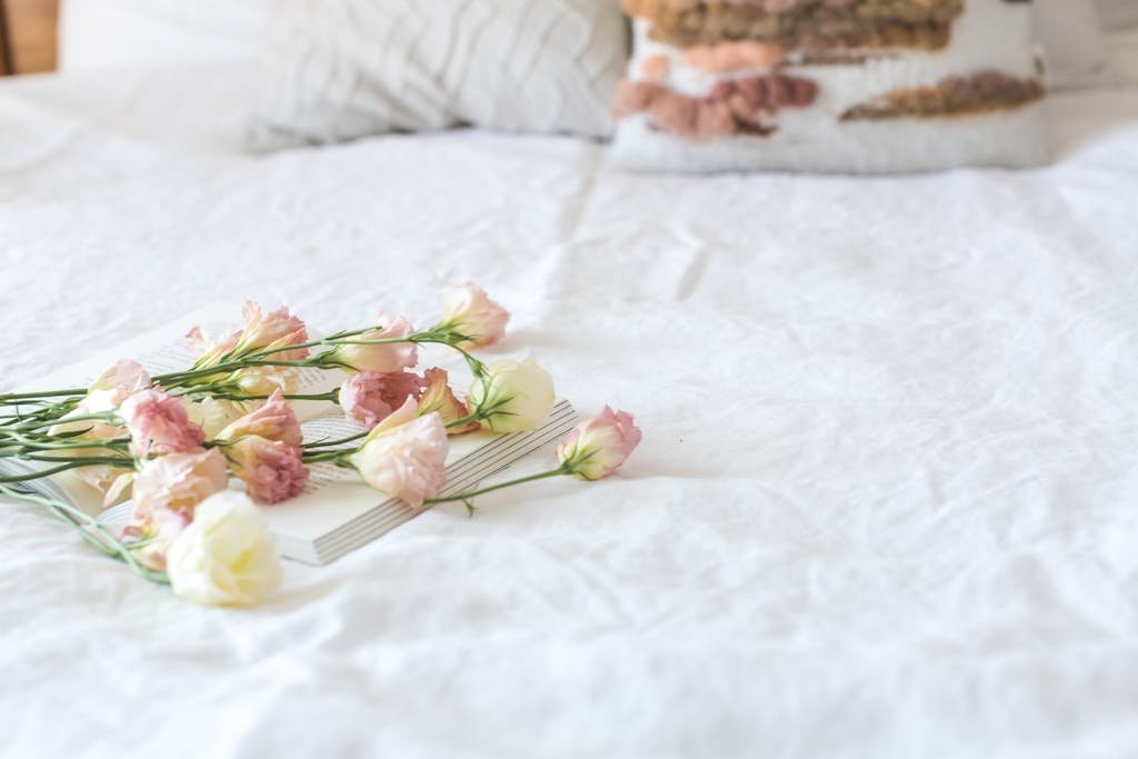 Delicate pink and white flowers on a bed, evoking romance and relaxation.
