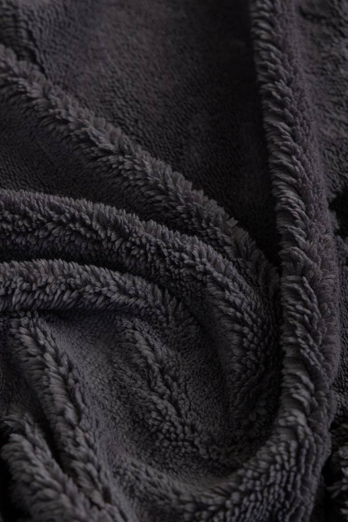 Detailed view of a plush black blanket highlighting its soft texture and luxurious feel.
