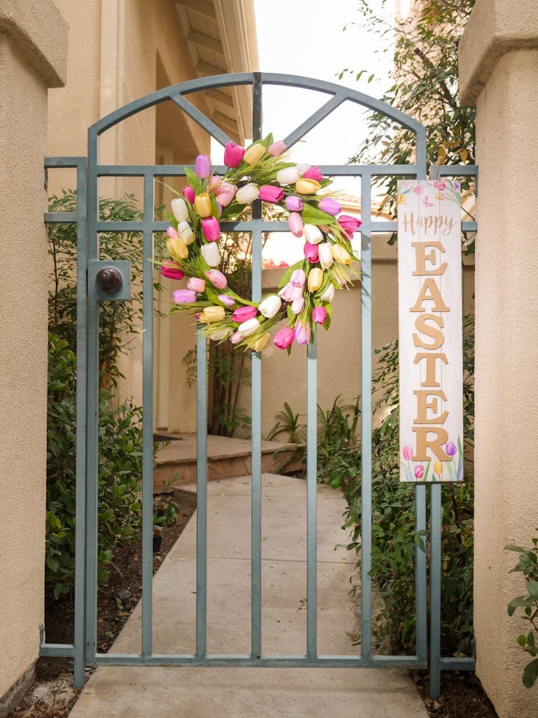 Elegant garden gate with a vibrant Easter wreath and sign, perfect for celebrating spring.
