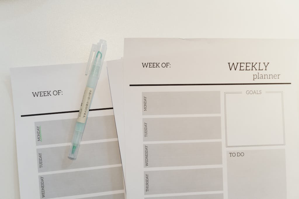Organized weekly planner sheets with a pen for efficient scheduling and goal setting.